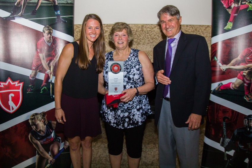 Janet Ellis recibe su distinción al Salón de la Fama de Field Hockey Canada de la capitana del equipo nacional femenino Kate Gillis (izquierda) y del Presidente de Field Hockey Canada  Ian Baggott (derecha) el 9 de julio de 2016 en Vancouver